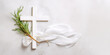 White christianity wooden cross with white silk ribbon and green fir branch on a light grey marble background with copy space. Christmas holidays. Christian religion background. Flat lay