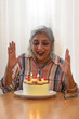 © IndiaPix - A MATURE ADULT WOMAN LOOKING AT CAKE WITH EXCITEMENT
