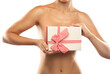 © Dimid - Nude female breast close-up. Near the chest is a gift box with bow Sexy slim woman with a naked torso on a white background.