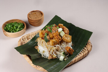 Wall Mural - Nasi Lengko is Indonesian Traditional Dish, Rice Topped With Fried Slices Tofu, Tempeh and Peanut Sauce.