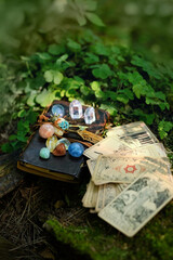 Wall Mural - witch book with set of minerals, vintage divination cards in forest, natural background. Gemstones for Magic Crystal Ritual. Witchcraft, spiritual esoteric practice. stone therapy, tarot reading.
