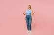 Full body elderly blonde woman 50s year old she wears blue undershirt casual clothes doing winner gesture celebrate clenching fists say yes isolated on plain pastel pink background. Lifestyle concept
