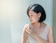 Portrait of Beautiful Asian woman with healthy skin, short black hair worried about her body skin. Middle aged woman checking her shoulder under sun light, skin care or beauty concept, copy space.