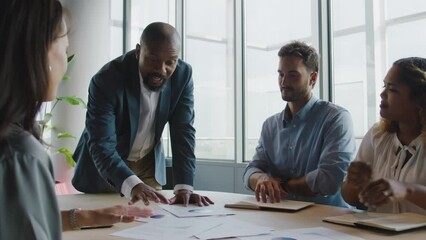 Wall Mural - Group of multiracial business people talking during meeting around conference table in office