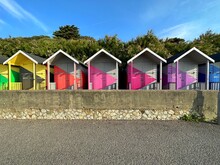 Row Of Multi Coloured Wooden Beach Huts On Beach, Folkestone, Kent, England, UK
