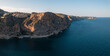 © AmazingAerialAgency - Aerial view of Breathtaking coastal panorama with clear blue sea, rugged cliffs, and the serene tranquility of small holiday houses, Cala Moraig, Zona Encinas, Cumbre del Sol, Alicante, Spain.