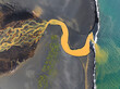 © AmazingAerialAgency - Aerial view of abstract water formation from river estuary along the coastline in Hvolsvollur, Southern Region, Iceland.