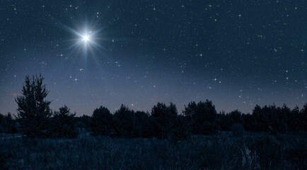 Poster - Bright star shines over the manger of christmas of Jesus Christ on blue starry sky