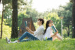 © Dialogue Frame - A young male and female couple are enjoying a pleasant picnic while drinking drinks and reading books on the forested park lawn.