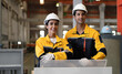 © Nassorn - Hispanic industrial engineers in white helmet and safety jacket working in heavy steel engineering factory. Latin technician workers in uniform standing in manufacturing facility, portrait.