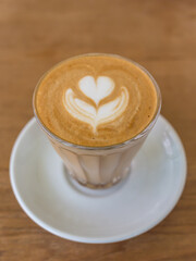 Wall Mural - latte art tulip trait in a glass on wooden table