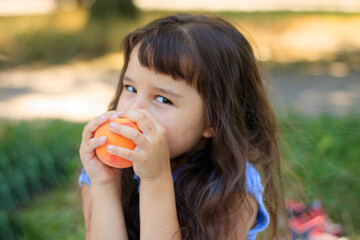 Pretty girl with peaches little girl is eating a peach