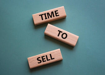 Time to Sell symbol. Concept words Time to Sell on wooden blocks. Beautiful grey green background. Business and Time to Sell concept. Copy space.