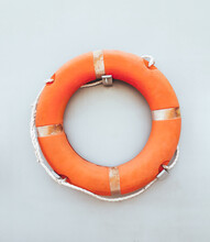 Orange Lifebuoy And Old Rope Hanging On A Boat