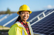 © pangamedia - A female asian engineer with a yellow helmet are checking on solar panels enthusiastic in a solar panel clean park ; renewable energy concept
