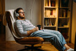 © cherryandbees - Caucasian man with eyes closed enjoying music with headphones while relaxing at home