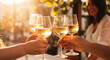 © swissa - Friends toasting white wine glasses in sunny winery or wedding, capturing joyful celebration