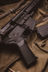 Canvas Print - Modern automatic carbine and backpack on a wooden table. A set of fighter ready for any battle conditions.