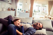 © Geber86 - Young Caucasian father playing with his son and having fun on the couch in the living room at home