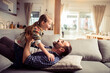 © Geber86 - Young Caucasian father playing and having fun with his daughter on the couch at home