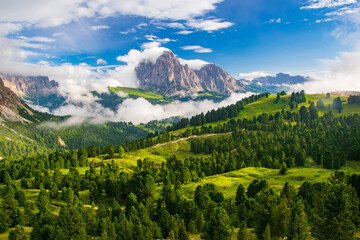 A vibrant depiction of the Sassolungo Massif and Gardena Valley in Dolomite Alps, Italy. The foreground showcases a lush green valley, while the background highlights a cloud-covered mountain peaks