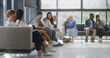 © Framestock - Diverse multicultural people sit on couches in clinic lobby area, wait for appointment with doctor or medical test results. Waiting area in medical center with modern design. Healthcare system.