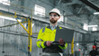 © ihorvsn - Portrait of mature bearded male engineer. Industrial manufactory worker is standing and holding laptop at construction. Architect dressed up in protective clothes and helmet inspecting work process.