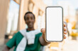 © Maria Vitkovska - Smiling African American man showing blank white mobile phone screen, mockup, place for text