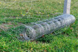 Złożone ogrodzenie z drutu leżące na trawie.