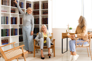 Canvas Print - Mature women reading books at home library