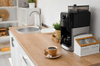 © Pixel-Shot - Modern coffee machine with cup of espresso on wooden counter in kitchen