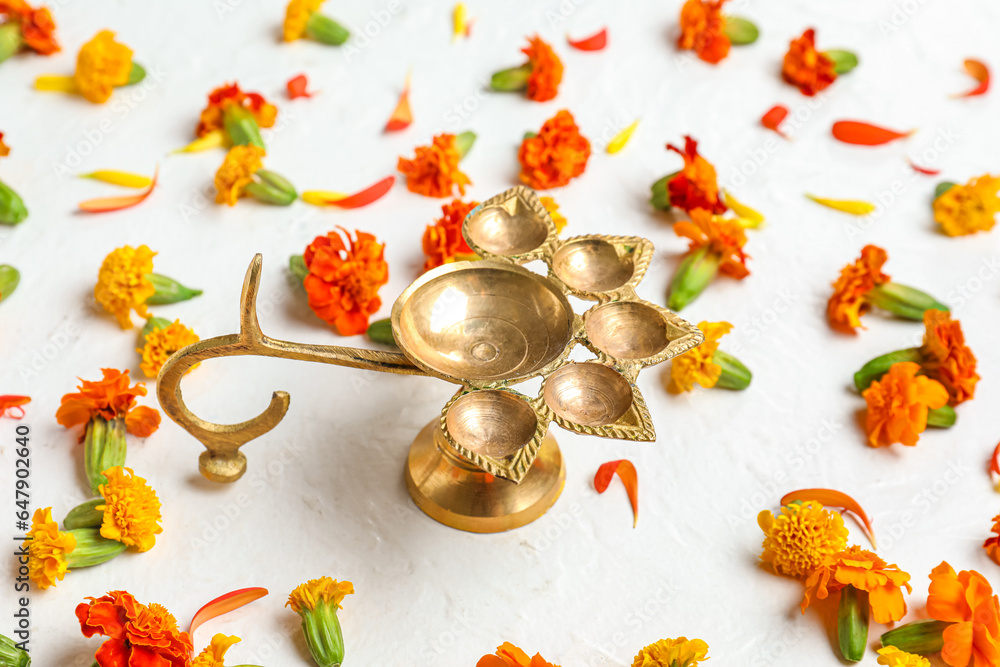 Diya lamp with marigold flowers on white background. Divaly celebration