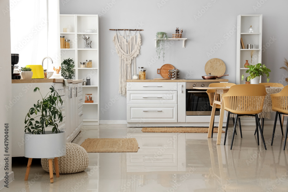 Interior of light kitchen with white counters and wicker carpets