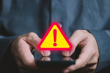 Wall Mural - businessman using laptop showing warning triangle and exclamation sign icon warning of dangerous pro