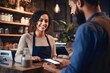 © Salsabila Ariadina - Female cashier in coffee shop smiling working serving customers who pay by credit card. Receive payments via NFC technology