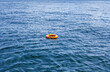 Orange life buoy floating in sea. Red lifebuoy float on ocean waves
