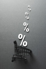 Wall Mural - Shopping trolley and white percent signs with copy space on grey background