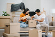 © Nuttapong punna - Young couple with big boxes moving into a new house, new apartment for couple, young asian man and woman helping to lift boxes on sofa for the new home, Moving house..