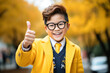 smiling Asian schoolboy wearing school uniform show thumb up finger on outdoor