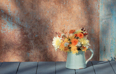 Poster - chrysanthemum flowers in jug on background old wall in sunlight