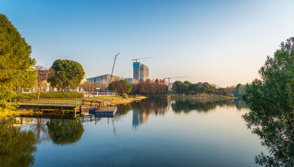 Wall Mural - A modern city by the lake at sunset