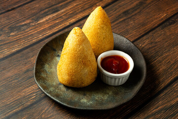 Wall Mural - two traditional Brazilian coxinhas. typical fried snack food stuffed with meat and chicken