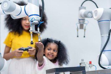 Wall Mural - Kid female teen child enjoy Machine Learning Robot arm is Moving Under Control robot at technology class, stem education robot arms for digital automation software for artificial intelligence ai