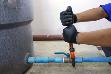 Wall Mural - Technician plumber using a wrench to repair a water pump pipe. Concept of maintenance, fix water plumbing leaks drop or house bathroom service or cleaning clogged pipes is dirty or rusty.