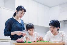子供と一緒にクッキングをする家族