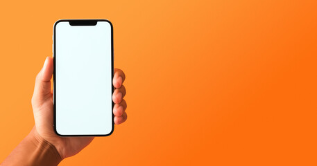 Mockup of hand holding smartphone with blank screen. Colorful orange banner with copy space.