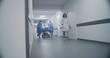 © Framestock - Doctors, nurses and paramedics run and push stretcher with seriously injured patient to surgery room. Medical personnel save human life in emergency department. Medical facility hallway. Slow motion.