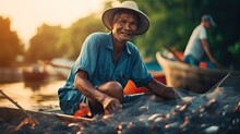 Older Man From Southeast Asia, Fishing With Nets In The Boat.