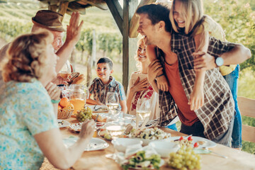 Wall Mural - Multigenerational family enjoying a lunch on the balcony of a house in a vineyard in the countryside