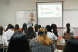 © EduLife Photos - Rear view of college students listen to teacher teaching and explaining lesson in classroom